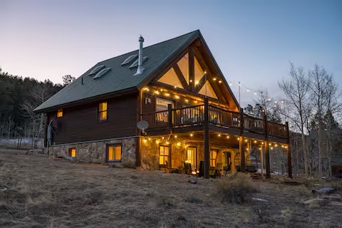 Skyfall Chalet exterior at dusk with string lights and mountain backdrop